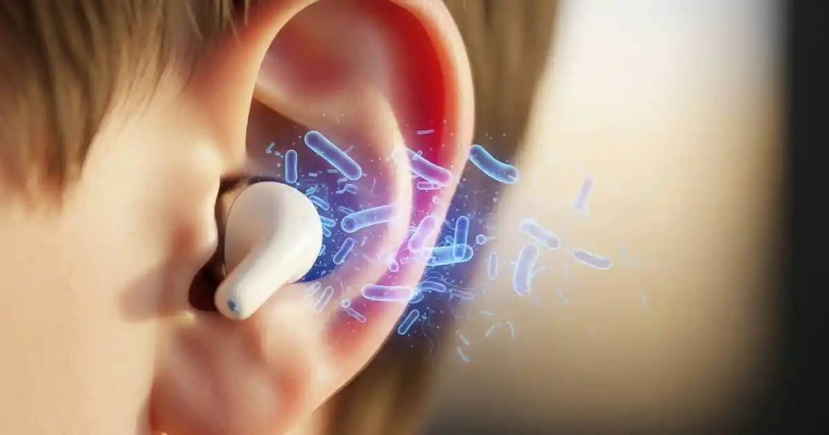 A close-up photograph of a person's ear with a white earbud, showing a stylized, glowing cloud of bacteria and germs in the ear canal and around the earbud.